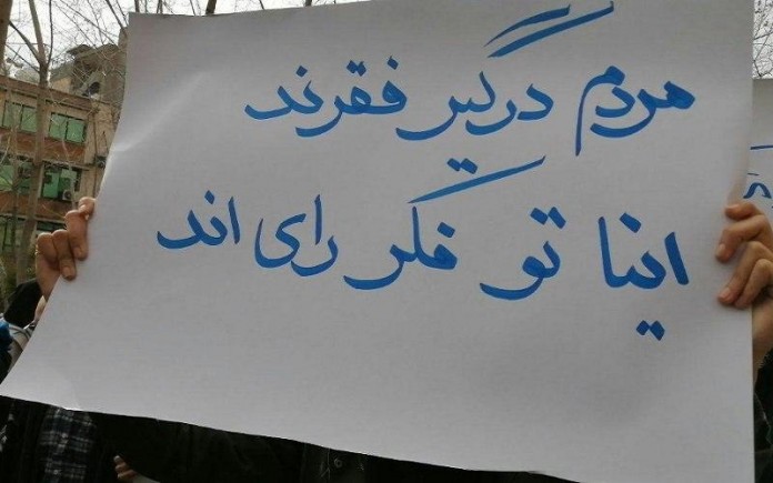 An Iranian holding a placard with the slogan: 